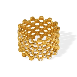 Vintage honeycomb hollow titanium gold-plated ring with Czech crystals on white background