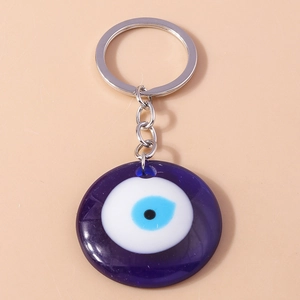 Close-up of glass Evil Eye keychain with blue protective eye charm and silver key ring