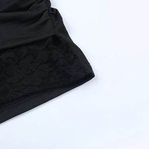 Detail of elegant black lace stitching and pleated fabric textures on the dress