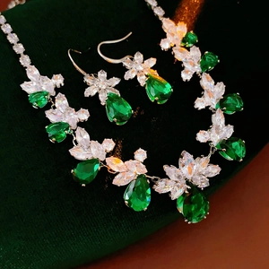 Détail du collier fleur et boucles d'oreilles avec pierres vertes et zircons clairs