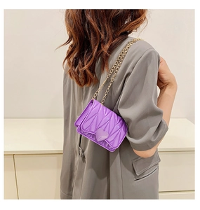 Detailed back view of a girl wearing a purple heart-shaped mini crossbody bag with gold chain