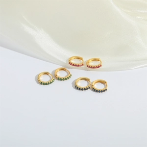 Three pairs of minimalist huggie earrings with red, green, and blue cubic zirconia stones