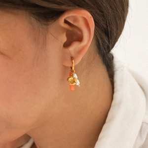 Gold stainless steel hoop earring with coral bead, flower charm and pearl on model