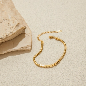 Dettaglio del bracciale a maglia serpente in acciaio oro 18K con perline geometriche lucide