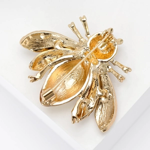 Reverse side view of golden enamel bee brooch showing secure metal pin fastening