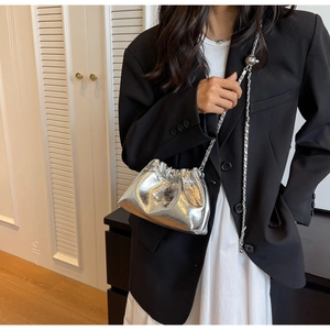 Chic silver metallic drawstring bucket bag with pleated texture and adjustable chain strap