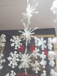 Close-up of white fuzzy snowflake ornaments with textured fibers for Christmas tree decor