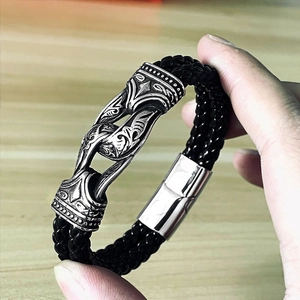 Close-up of black braided leather bracelet with Viking pattern silver metal clasp