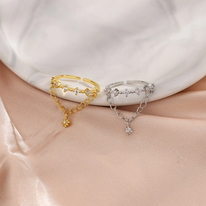 Detailed view of double layer star rings with zircon pendants on marble and silk