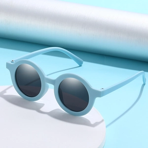 Sky blue round kids sunglasses with dark grey lenses on a white display stand