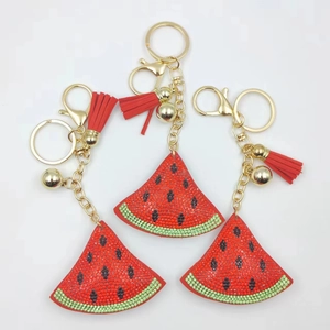 Detailed view of rhinestone watermelon slices with red leather tassels and gold keyrings