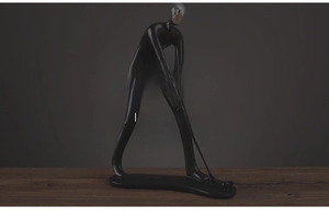 Détail d'une statue de golfeur en résine noire moderne avec une pose dynamique