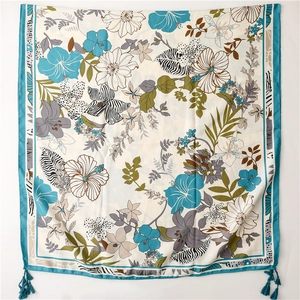 Detail of tropical floral scarf with zebra pattern leaves and turquoise tassels