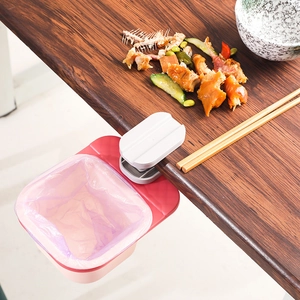 Pink and white rotating clip-on desk trash bin for small waste on a wooden table edge
