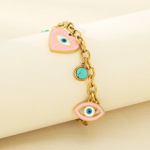 Nahaufnahme eines goldenen Gliederkettenarmbands mit Herz-, Auge- und Türkisanhängern