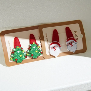 Detail of Christmas hair clips set with green sequin tree and embroidered Santa on card