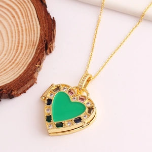 Golden heart necklace with green gem and colorful zircon accents on wood background