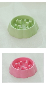 Detail view of slow feeder dog bowls in green and pink with bone-shaped obstacles