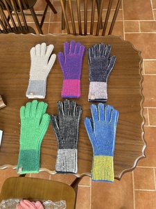 Detalle de seis guantes de punto de colores con patrones de rayas y función de pantalla táctil