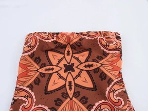 Détail de tissu bohème à motif mandala marron et orange avec finition élastique froncée