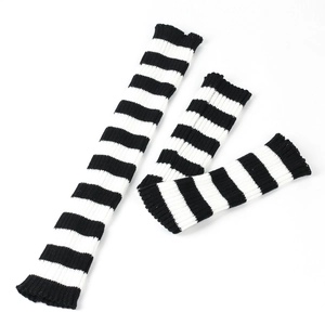 Detailed close-up of thick black and white striped knit leg warmer fabric texture