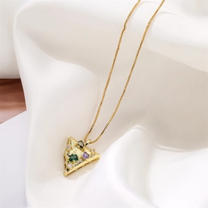Macro shot of gold triangular pendant with multi-colored gems on white silk