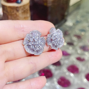 Close-up of sparkling camellia flower stud earrings with inlaid cubic zirconia crystals