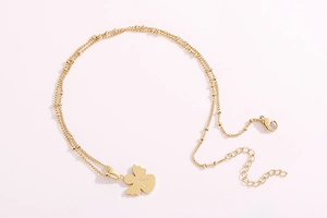 Dettaglio della collana ali d'angelo dorata con ciondolo lettera A e catena