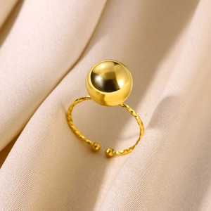 Detail of gold open ring featuring a spherical bead and woven texture on champagne silk