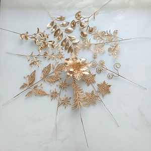 Assortiment de feuilles artificielles dorées pour compositions florales sur fond marbre