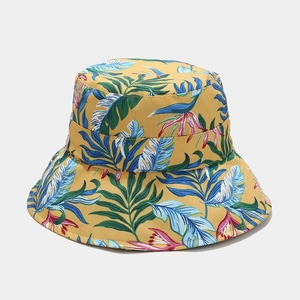 Close-up of tropical palm leaf and flower prints on a yellow foldable sun bucket hat