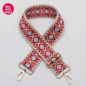 Macro detail of geometric ethnic pattern bag strap with golden lobster clasps and buckles