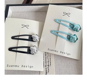 Close-up of star-shaped BB hair clips in black and blue on brand display cards