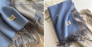 Detailed close-up of double-sided cashmere scarf in denim blue and beige grey with fringe