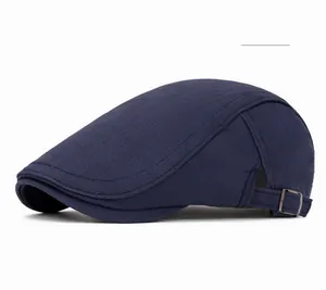 Detail of the navy blue cotton flat cap showing a metal adjustment buckle on the back
