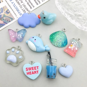 Flat lay of colorful resin charms including cute whale, shell, and heart shapes for DIY jewelry