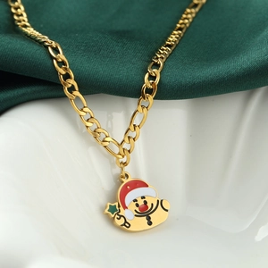 Christmas necklace with Santa pendant on gold Figaro chain against green silk backdrop