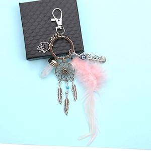 Detail of dreamcatcher keychain with pink feather, Hamsa hand, and blue evil eye bead