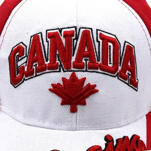 Close-up of 3D embroidered Canada text and red maple leaf on a white cotton baseball cap