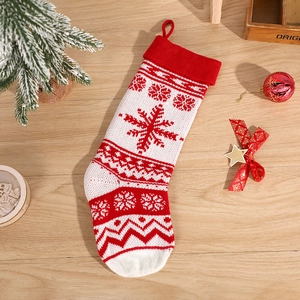 Knitted Christmas stocking with snowflake patterns on a rustic wooden background