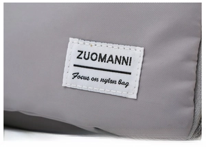 Close-up of waterproof gray nylon fabric and stitched brand label on sports duffel bag