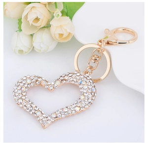 Detailed view of a gold heart keychain with sparkling rhinestones on a soft background