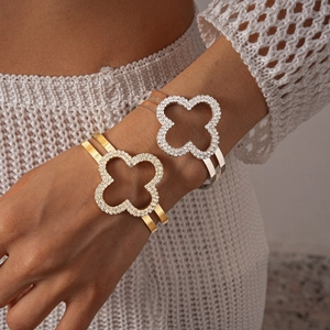 Dettaglio di bracciali a doppio strato a quadrifoglio con incastonatura di diamanti lucidi