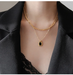 Close-up of double-layered titanium steel necklace with rectangular black enamel pendant