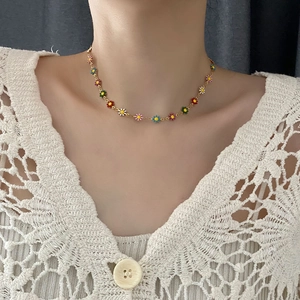 Colorful beaded daisy necklace with enamel flower charms on a gold-plated link chain