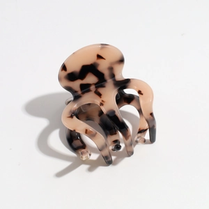 Detailed view of octopus hair claw clip with amber tortoise shell pattern and glossy finish
