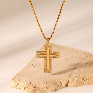 18K gold plated stainless steel cross necklace with diamonds on a textured stone base