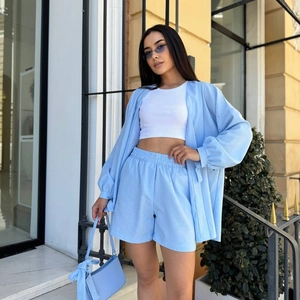 Détail d'un ensemble décontracté bleu clair trois pièces avec haut à lacets et short taille haute