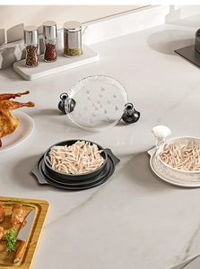 Detail view of manual chicken shredder with shredded meat on kitchen counter
