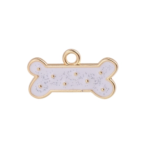Detailed close-up of a bone-shaped golden alloy pendant with white glittery enamel inlay